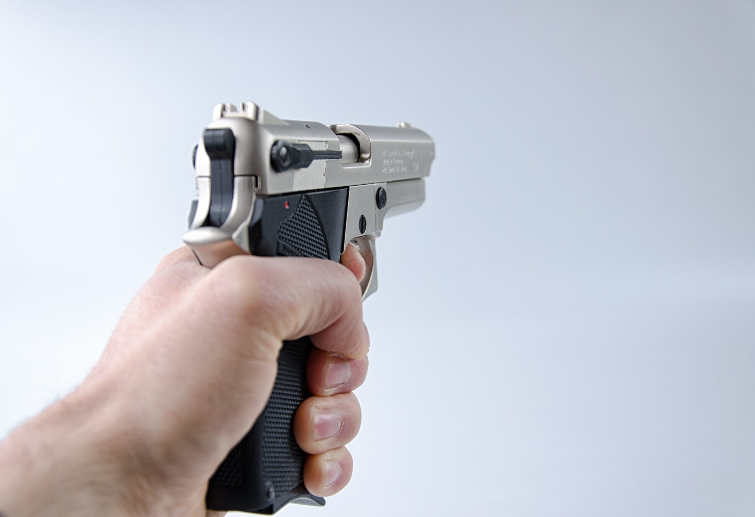 Mano che impugna una pistola a due mani, immagine a corredo dell'articolo sulla legittima difesa di un gioielliere